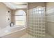 Bathroom showcases a soaking tub with an arched window and a separate glass block shower at 201 Bayside Ct, Nokomis, FL 34275