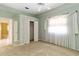 This bedroom includes carpet flooring, closet, a bright window with lovely sheer curtains, and a mirror on a closet door at 201 Bayside Ct, Nokomis, FL 34275