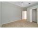This cozy bedroom includes carpet flooring, a ceiling fan, and an open door leading to another room at 201 Bayside Ct, Nokomis, FL 34275