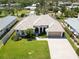 Aerial view of a single-story home with a well-manicured lawn, mature trees, and a spacious driveway at 201 Bayside Ct, Nokomis, FL 34275