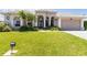 Beautiful home featuring a well-manicured lawn and double door entry framed by columns and arched windows at 201 Bayside Ct, Nokomis, FL 34275