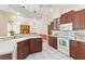 Bright kitchen with wooden cabinets, tile flooring, stainless steel appliances, and a center island with counter space at 201 Bayside Ct, Nokomis, FL 34275
