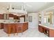 Open-concept kitchen with an island, wooden cabinets, and bar seating, offering ample counter space and storage at 201 Bayside Ct, Nokomis, FL 34275
