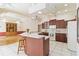 Spacious kitchen features wooden cabinets, tile flooring, white appliances, and a center island with bar stool seating at 201 Bayside Ct, Nokomis, FL 34275