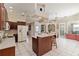 Large kitchen with dark cabinets, white countertops, white appliances, island with seating and views to dining and living areas at 201 Bayside Ct, Nokomis, FL 34275