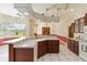 Spacious kitchen boasts a center island, ample counter space, dark cabinets, and seamless flow to the outdoor pool area at 201 Bayside Ct, Nokomis, FL 34275