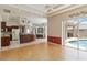 Open-concept living area with hardwood floors, pool view, connected to the kitchen and features high ceilings and natural light at 201 Bayside Ct, Nokomis, FL 34275