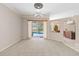 Bright living room featuring sliding glass door to backyard, ceiling fan, and views to kitchen at 201 Bayside Ct, Nokomis, FL 34275