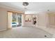 Open living room with sliding glass door to pool area, carpet floors, and view to kitchen area at 201 Bayside Ct, Nokomis, FL 34275