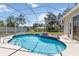 Backyard pool area with a covered enclosure, fountain feature, and well-manicured landscaping for outdoor enjoyment at 201 Bayside Ct, Nokomis, FL 34275