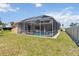 A screened-in pool with clear water, surrounded by lush greenery and a well-maintained lawn at 201 Bayside Ct, Nokomis, FL 34275