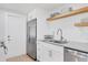 Close-up of a kitchen with white cabinets, stainless-steel appliances, and wood shelves at 203 Palm Ave, Nokomis, FL 34275