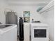 Laundry room featuring white washer and dryer, and a water filtration system at 203 Palm Ave, Nokomis, FL 34275