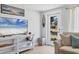 A cozy living room with a comfortable couch, surfboard, and a TV creating an inviting space at 203 Palm Ave, Nokomis, FL 34275
