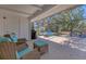 Covered patio showcasing wicker seating and view of the spacious backyard with a grill at 203 Palm Ave, Nokomis, FL 34275