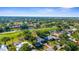 An aerial shot shows a community with golf course views, lush landscaping, and sunny skies at 2187 Calusa Lakes Blvd, Nokomis, FL 34275