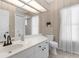Well-lit bathroom with white cabinets, a toilet, a mirror, and a shower behind a door at 2187 Calusa Lakes Blvd, Nokomis, FL 34275