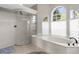 Upscale bathroom highlighting a spacious glass shower, a luxurious garden tub, and arch window to let in light at 2187 Calusa Lakes Blvd, Nokomis, FL 34275