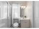 Small bathroom featuring a shower, toilet, and vanity with decorative wallpaper and neutral color scheme at 2187 Calusa Lakes Blvd, Nokomis, FL 34275