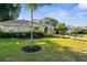 Landscaped front yard with lush lawn and mature tropical plants surrounding this lovely home at 2187 Calusa Lakes Blvd, Nokomis, FL 34275