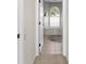 Carpeted hallway leading to a bathroom which features tiled floors and arched window letting in plenty of natural light at 2187 Calusa Lakes Blvd, Nokomis, FL 34275