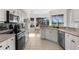 Well-lit kitchen featuring a black cooktop and stainless steel dishwasher with an adjacent dining area overlooking the backyard at 2187 Calusa Lakes Blvd, Nokomis, FL 34275