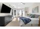 Bright bedroom features a flat screen TV, dresser and plush queen bed situated in front of a sun-drenched bay window at 2187 Calusa Lakes Blvd, Nokomis, FL 34275