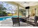 Covered patio with a pool, outdoor seating, and ceiling fan for relaxing outdoors at 2187 Calusa Lakes Blvd, Nokomis, FL 34275