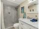 Updated bathroom featuring a walk-in shower with gray tile and a marble vanity at 230 Santa Maria St # 333, Venice, FL 34285
