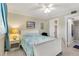 Bright bedroom with a queen-sized bed, coastal decor, ceiling fan, and ensuite bath at 230 Santa Maria St # 333, Venice, FL 34285