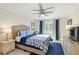 Comfortable bedroom with blue accents, a ceiling fan, and large window with natural light at 230 Santa Maria St # 333, Venice, FL 34285