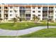 Exterior view of the building with lush green lawn and landscaping at 230 Santa Maria St # 333, Venice, FL 34285