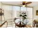 Bright dining area features a glass table, designer fan, and light-filled windows with vertical blinds at 230 Santa Maria St # 333, Venice, FL 34285