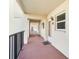 Exterior hallway leading to unit 333, featuring neutral paint, a black railing, and exterior windows with blinds at 230 Santa Maria St # 333, Venice, FL 34285