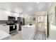 Bright kitchen with stainless steel appliances, white cabinets, a quartz countertop island, and access to the outdoor balcony at 230 Santa Maria St # 333, Venice, FL 34285