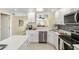 Updated kitchen features white cabinets, quartz countertops, stainless steel appliances, and an opening to the living room at 230 Santa Maria St # 333, Venice, FL 34285