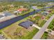 An elevated view capturing a single-story residence near a waterfront with verdant lawns and a peaceful neighborhood ambience at 233 Rotonda Cir, Rotonda West, FL 33947
