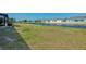 Expansive backyard with healthy grass and a tranquil waterfront view bordered by new houses across the water at 233 Rotonda Cir, Rotonda West, FL 33947