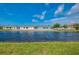 View of the backyard, canal, and neighboring homes under a bright blue sky with fluffy clouds at 233 Rotonda Cir, Rotonda West, FL 33947