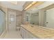 Spacious bathroom with a long vanity, toilet and shower/tub combo with a glass door at 233 Rotonda Cir, Rotonda West, FL 33947