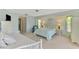Bright bedroom with a bed dressed in floral bedding, white furnishings, and views to an ensuite bath at 233 Rotonda Cir, Rotonda West, FL 33947