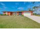 This property has lush green lawns and great curb appeal with an attached garage at 233 Rotonda Cir, Rotonda West, FL 33947