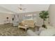 Cozy living room with wood-look flooring, neutral tones, and plenty of natural light from large window at 233 Rotonda Cir, Rotonda West, FL 33947