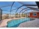 Sparkling in-ground screened pool with tiled deck and views of the adjacent canal at 233 Rotonda Cir, Rotonda West, FL 33947