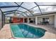 The in-ground pool has an enclosure, backyard views, and poolside seating at 233 Rotonda Cir, Rotonda West, FL 33947