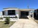 Delightful single-story home with a covered carport, enclosed porch, and landscaped garden bed at 235 Trailorama Dr, North Port, FL 34287