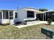Quaint single-story home with a covered carport, screened porch, and manicured landscaping at 235 Trailorama Dr, North Port, FL 34287