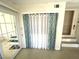 Hallway with a sliding glass door and closet covered with white and turquoise curtains at 235 Trailorama Dr, North Port, FL 34287