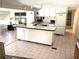 Cozy kitchen with tile countertops, breakfast bar, and bright white cabinets, perfect for casual dining at 235 Trailorama Dr, North Port, FL 34287