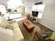Open-concept living area with comfortable seating, wood floors, and seamless kitchen access at 235 Trailorama Dr, North Port, FL 34287